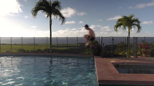 Junger Mann auf Hawaii springt in den Pool