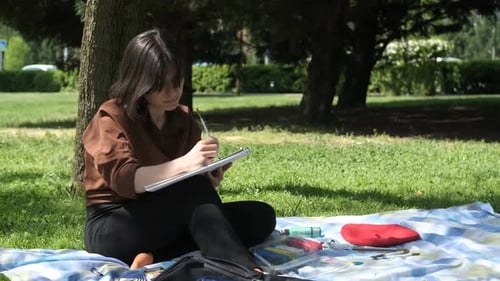 Young Woman Painting in Park on Sunny Day
