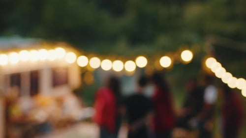 Dois amigos multirraciais tomando seus coquetéis chiques em primeiro plano perto do ônibus da festa com