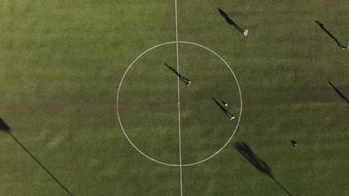 children playing soccer practice for passing the ball in the center circle of the football field