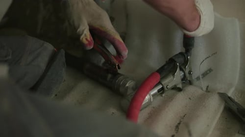 Man Uses Tool To Tighten Black Pipe