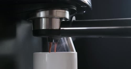 Home Espresso Making Process Coffee Stream Pouring From Machine Into Ceramic Cup