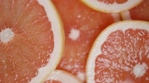 Nahaufnahme einer geschnittenen Grapefruit vor dem Hintergrund anderer Scheiben.