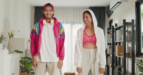 Two Young Adults Dancing and Laughing in Living Room