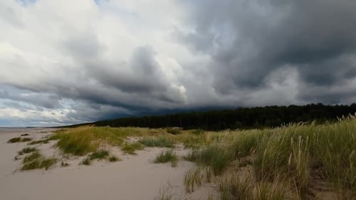 Stimmungsvoller und düsterer stürmischer Himmel über windiger Ostsee und Sandstrand