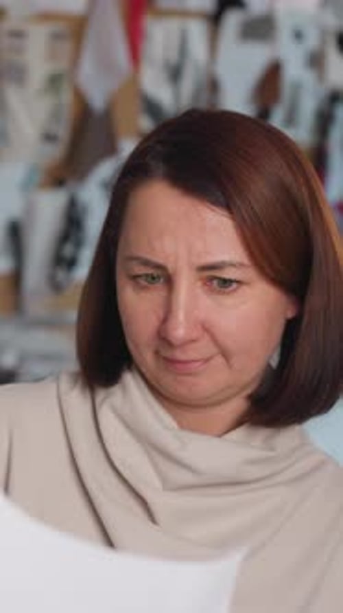 Sitzung zur Designkritik: Frau evaluiert Projekt mit Kollegen inmitten kreativer Teamarbeit