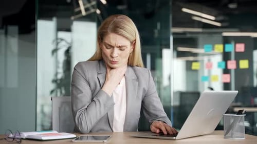 Businesswoman Working in Office Suffering With Sore Throat