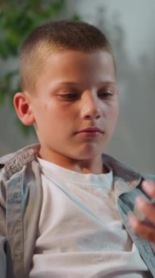 Young Boy Talking on Mobile Phone Indoors