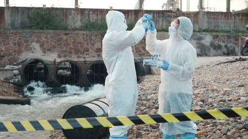Ecologist Sampling Water From the River with Test Tube