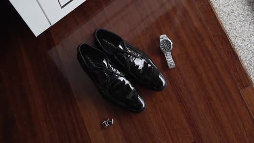 Elegant Black Shoes and Watch on Wood Floor