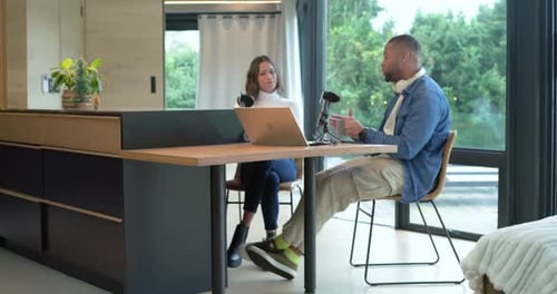 Pendant la discussion, divers collègues ajustent le microphone, enfilent des casques au studio pour préparer l'enregistrement