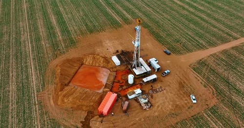 Location in the vast field with orange soil used for oil drilling.