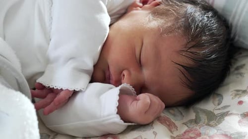 Close Up Newborn Baby Sleeping Peacefully on Bed