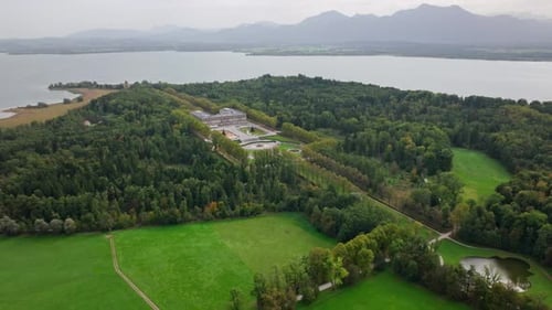 Nuevo palacio de Herrenchiemsee rodeado de árboles verdes junto al lago Chiemsee en la isla Herreninsel, Baviera,