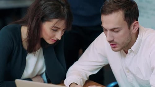 Colleagues Reviewing Data on Smartphone Device in Office