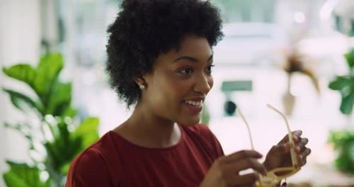Chic black woman tries on yellow sunglasses in sunny toronto boutique