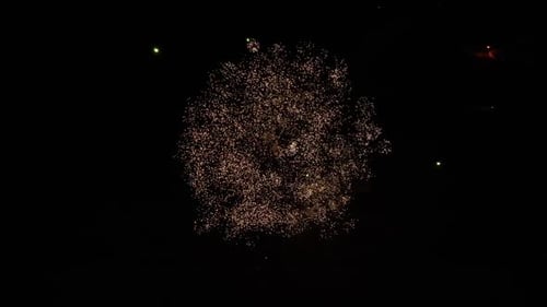 Massive firework explosion in the night sky. Several fireworks going off captured by a drone.