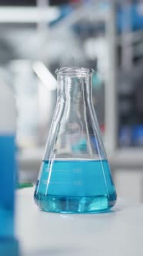 Vidéo verticale en gros plan d'un établi de laboratoire rempli de solutions chimiques colorées