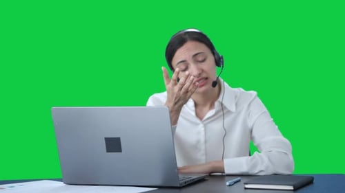 Stressed tensed Indian call center girl talking to the customer Green screen