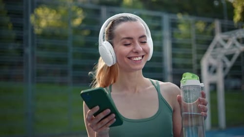 Woman Dancing After Morning Running in City Listen to Music in White Headphones