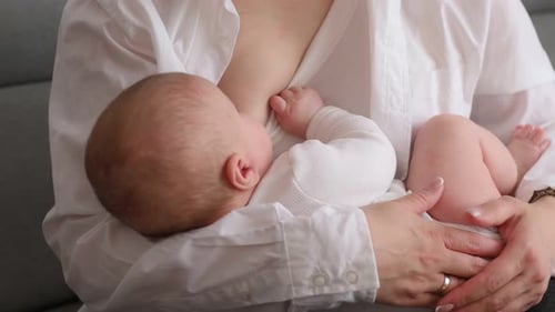 Mother breastfeeding her baby in a white shirt