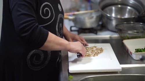 Adult Chopping Mushrooms with a Mezzaluna Chopper