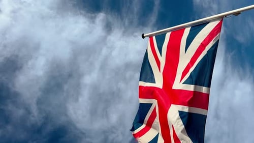 Flagge der zerrissenen Flagge Englands weht im Wind, Großbritannien, blauer Himmel und Wolken