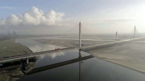 Energy icon overlay following electric vehicle crossing Mersey gateway bridge aerial view