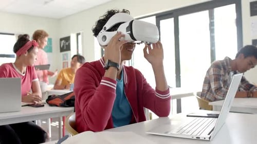 Using VR headset, teenager in high school classroom interacting with virtual environment