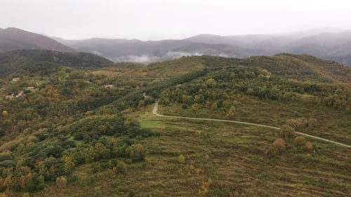 Scenic Aerial View of Rolling Green Hills and Mountains