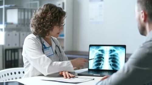 Female Doctor Explaining Chest X-Ray Results to Patient in Medical Office