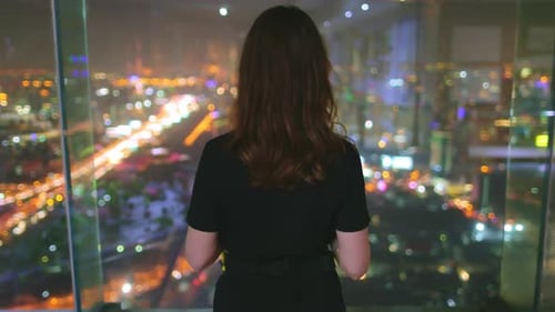 Rascacielos del último piso para mujer que disfruta de la vida nocturna en la ciudad