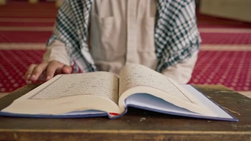 Islamic prayer concept Muslim man carefully studies the Holy Quran and prays to Allah in the mosque