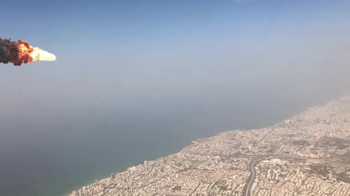 Meteor or asteroid breaks up over the clouds and large city, Aerial