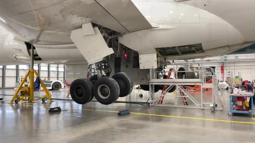 O trem de pouso de uma aeronave grande se estende e se retrai na fuselagem.