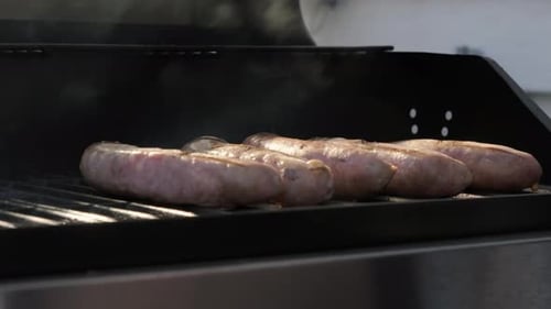 Grill Sausage on a Charcoal Barbecue Grill with a Fire