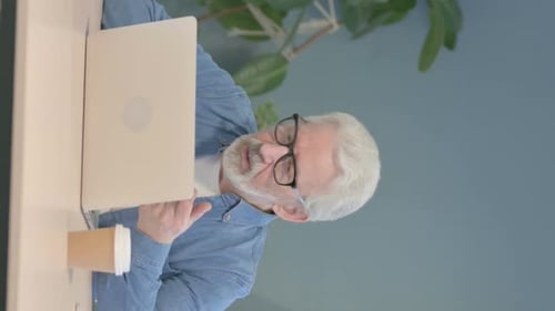 Senior Man Working on Laptop at Desk
