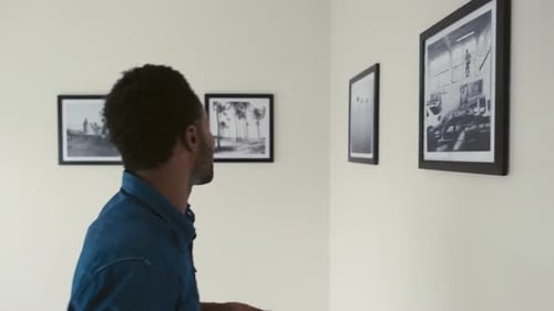 Visitante tomando fotografías con el teléfono de la exposición fotográfica