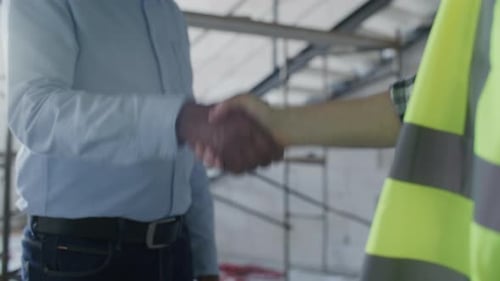 Close Up of Handshake between Businessman and Construction Worker on Site
