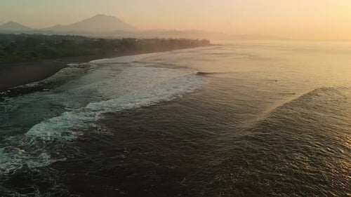 Luftaufnahme der malerischen Küste mit Vulkan, warmen Sonnenauf- oder Sonnenuntergangstönen und Meer mit Wellen