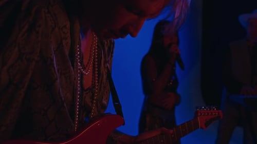Stylish Guitarist Playing on Amplified Guitar During Concert in Club