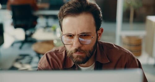 Thinking, man and reading on computer in office for research, review article or editing draft