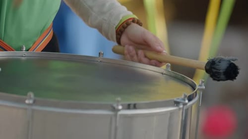 Straßenmusiker spielt die hängende Trommel mit den Pinsel hautnah auf einem Festival im Freien