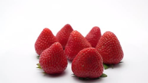Eine rotierende Anordnung ganzer Erdbeeren zeigt ihre satte Farbe und Textur.