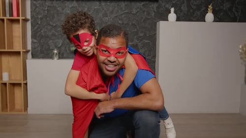 Father and Child Playing Superheroes at Home