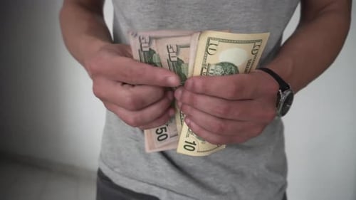 man counting dollars to pay