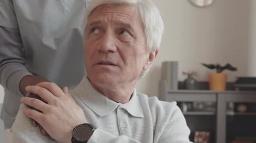 Nurse Supporting Sad Old Man