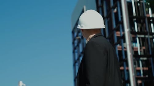 portrait of a successful handsome engineer, architect, builder, businessman in a white helmet, in a