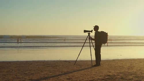 Photographer with Camera on Beach at Sunset