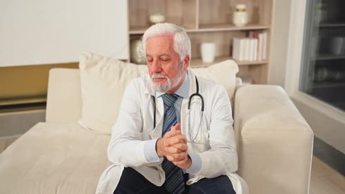 Sad Tired Mature Senior Male Doctor in Medical Uniform in Hospital or Doctor Office Unhappy General